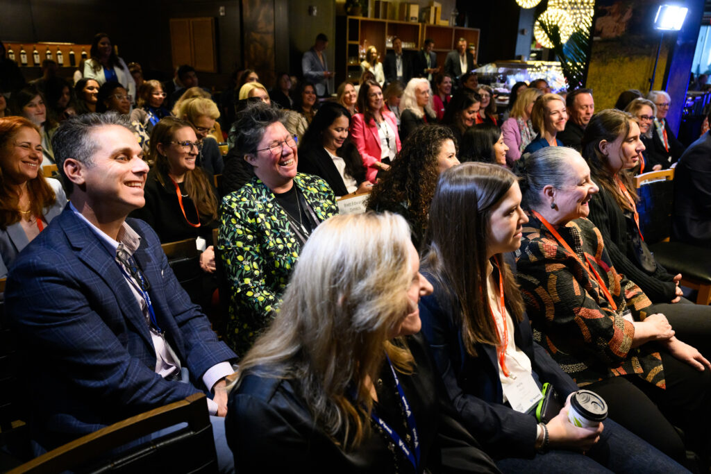 Audience members smiling and laughing