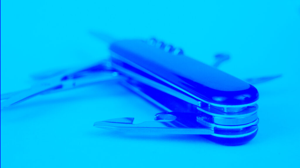 A photo of a Swiss Army knife with a blue overlay. The Swiss Army knife represents how much better it is to consolidate to one tool that does many things instead of having separate tools that spread resources.