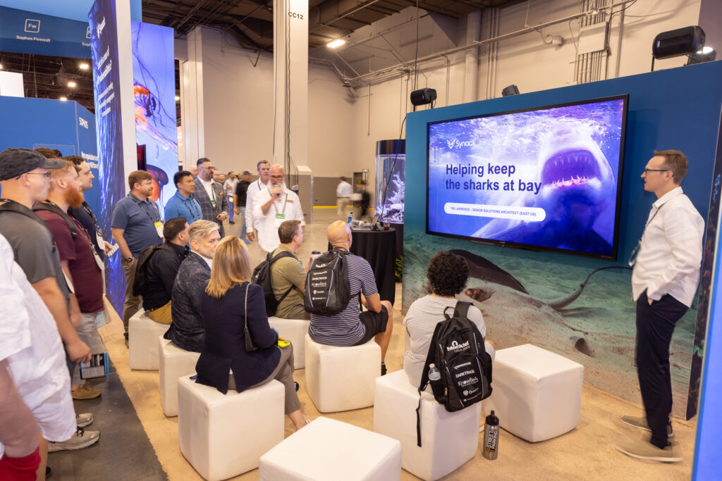 Attendees at Black Hat 2023 fill the Cave at the Synack booth to hear more about the Synack Platform in action.
