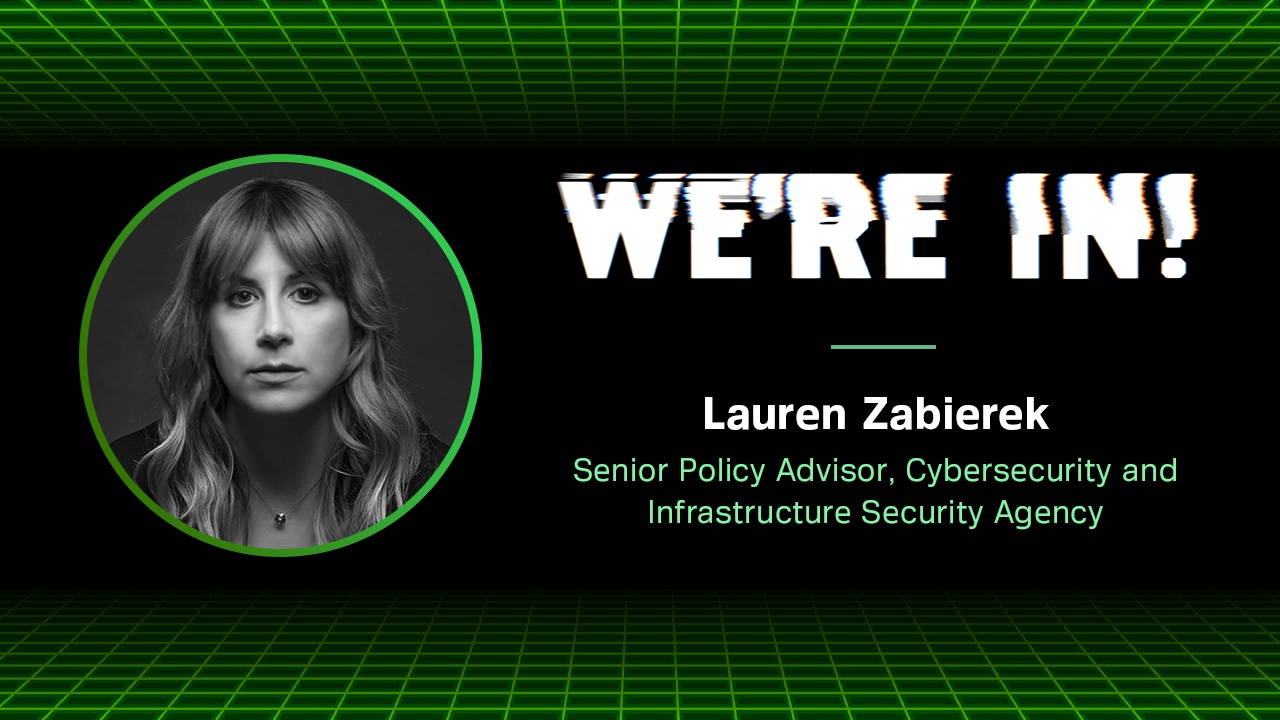 Black-and-white portrait photo of Lauren Zabierek, with lower third identifying her as Senior Policy Advisor, Cybersecurity and Infrastructure Security Agency. against a green-and-black backdrop with the words WE'ER IN! emblazoned on it in white.