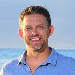Matt Cappello, Sales Director Americas at Synack, smiling outdoors with the ocean in the background.